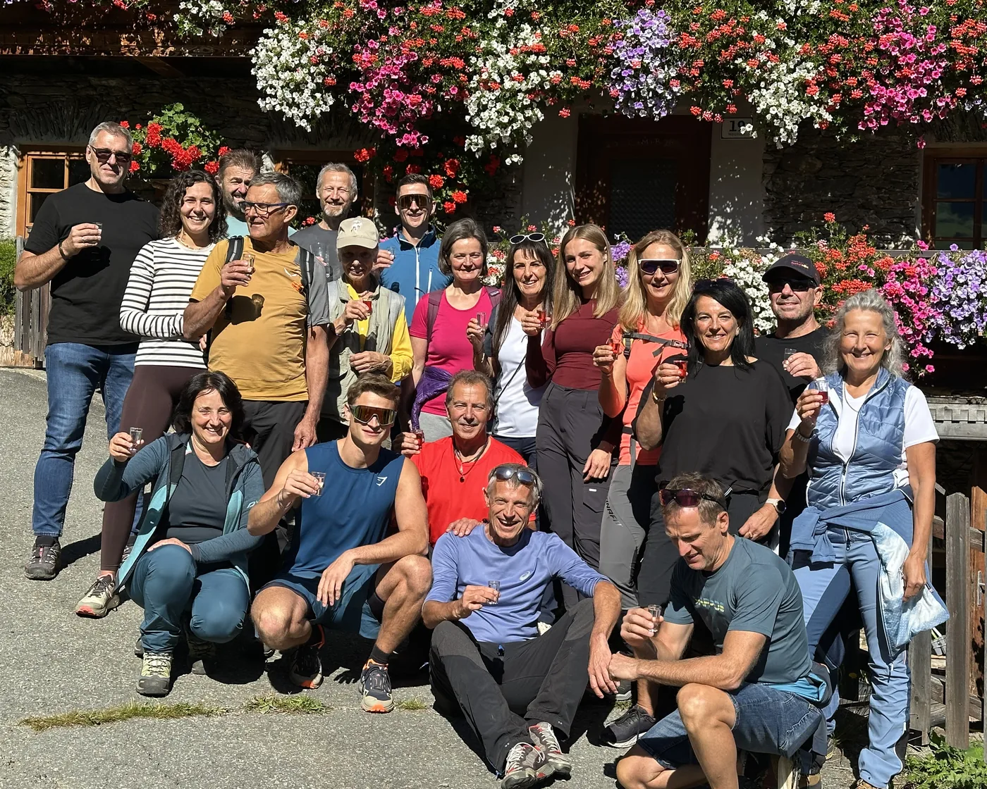 Gruppenfoto der Teilnehmenden beim TopFit-Club-Retreat in Osttirol vor einem blumengeschmückten Bauernhaus